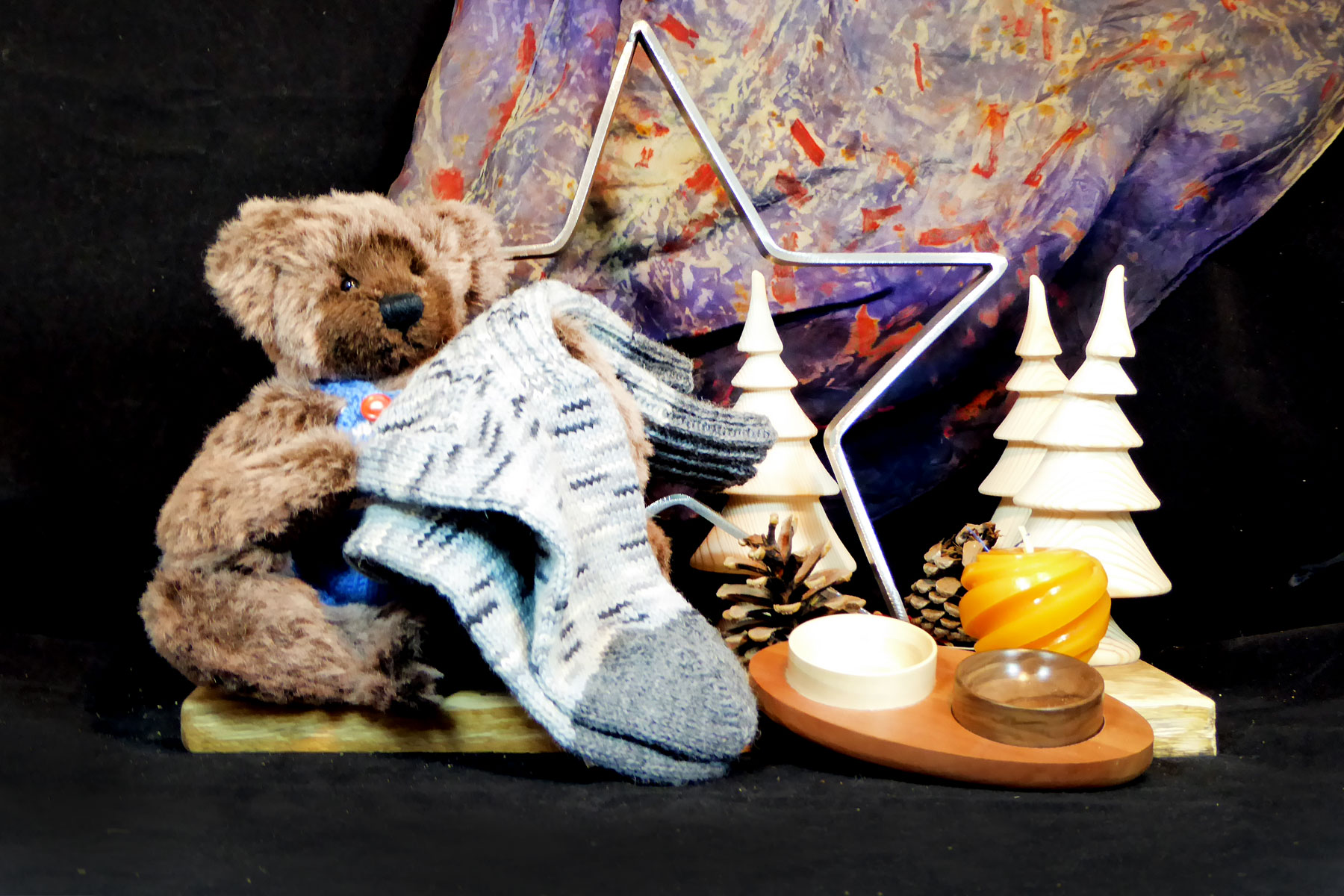 Braunes Arrangement mit Ecoprinttuch, Teddybär, Socken, gedrechselten Bäumchen, Kerze